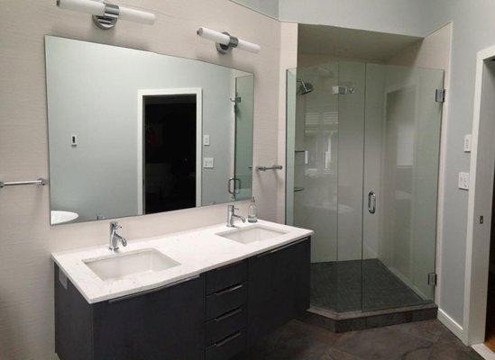 Frameless shower enclosure and mirror over vanity