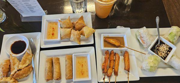 Appetizers: Left to right: fried dumplings, top-crab ragoons, bottom-egg rolls, chicken satays on a stick, & spring rolls