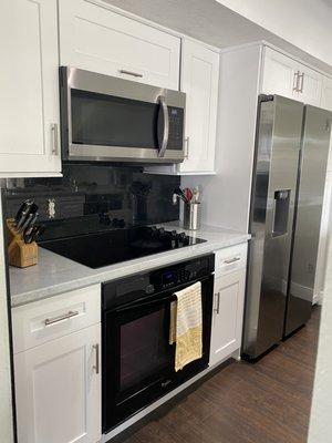 After, the appliances and trash bin are on this side of the kitchen.