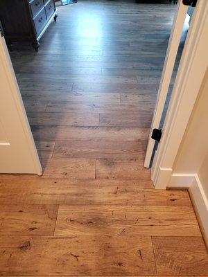 Showing original flooring in hall and new installation match in bedroom.