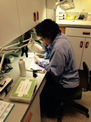 Pam hard at work cleaning a patient's hearing aids.