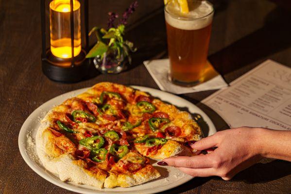 Spicy Meat Lovers Pizza with house-made dough, San Marzano sauce, pepperoni, sausage, jalapeños, Calabrian chili, and mozzarella.