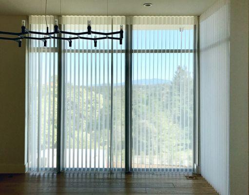 This Los Altos home's tall window, use Hunter Douglas Luminette to give UV protection & to create an elegant look for the formal  dining.