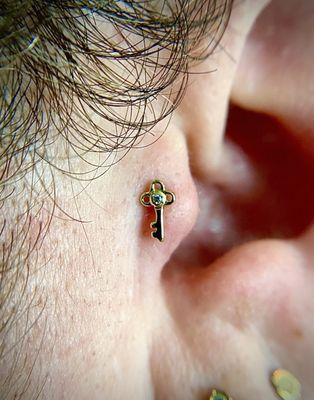 Tragus piercing with 14k Gold Threadless Key with Swarovski Bezel.