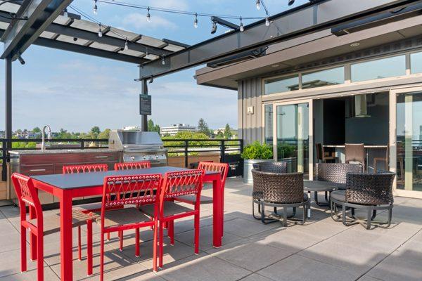 Rooftop terrace with BBQ area, overhead heaters, and lounge seating.