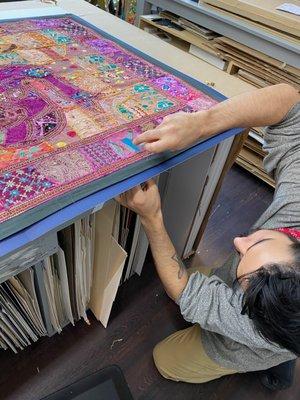 Sewing down a large tapestry made of vintage Sari's.