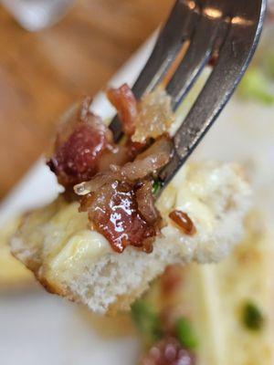 A fork holding a Bacon Jam Apple Brie Crostini apertizer.