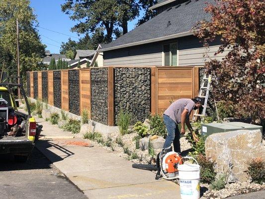 Wood fence and wire rock panels