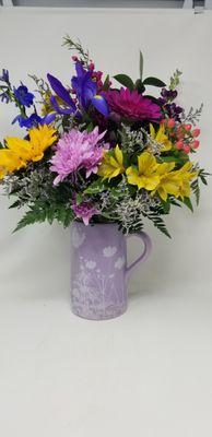 A ceramic pitcher filled with fresh flowers.