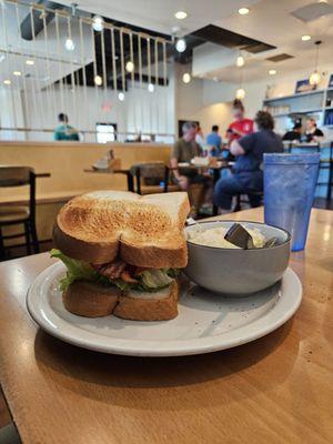 BLT breakfast sandwich with egg, lettuce, & tomatoes,  grits & coffee