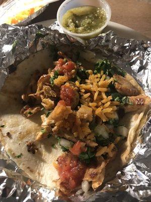 Food - Chicken street taco topped with cilantro, onions, lime, beans and rice and a side of chips and homemade salsa