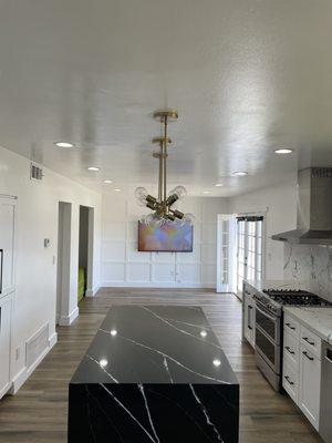 Recessed lighting and hanging lights over island aligned perfectly to elevate the entire look of the space