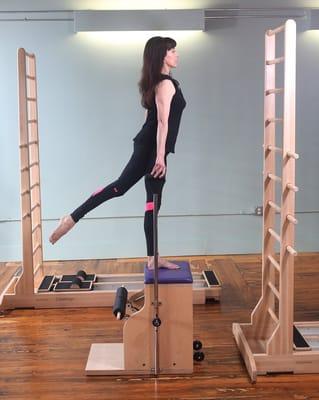 Step up exercise on the Balanced Body Combo Split Pedal Chair with CoreAlign in the background.  Photo by Carolyn Bauman Cruz.