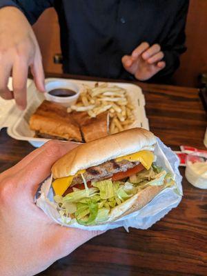 Hamburger (foreground) and french dip with fries (background)