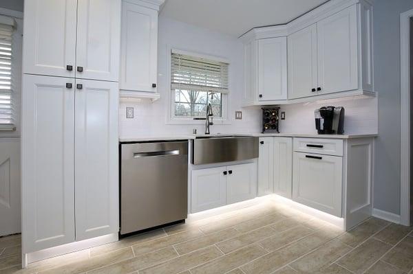 White floor to ceiling cabinetry, quartz countertops, under cabinet lighting, stainless apron sink, custom backsplash and more.