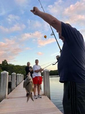 Fishing from pier at river camp