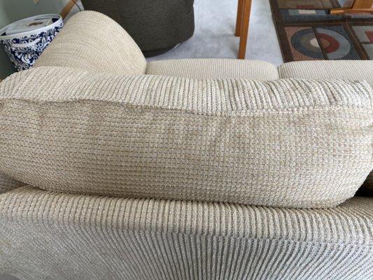 Repaired cushion. They cut apart an arm cushion and used that material to cover the damage. It looks like new!