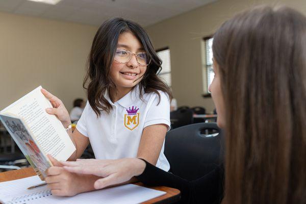 4th grade student discussing her novel with her teacher