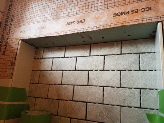 The orange water protection system was supposed to cover all walls in shower area. They cut corners in the shampoo shelf area.