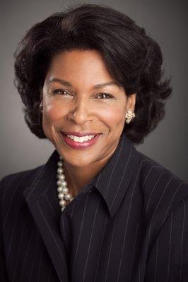 Corporate headshot with dark grey background, Hancock Headshots, New York, NY.  Beautiful African American, black woman with pearls.