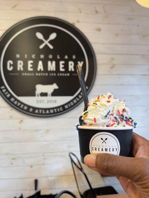 Sweet corn ice cream with whipped cream and rainbow sprinkles.