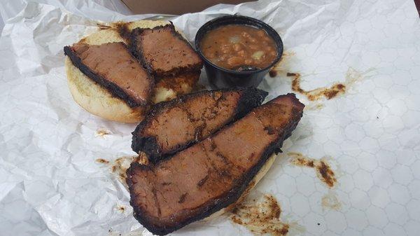 Texas Brisket Sandwich with a side of beans.