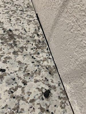 Counter top against the wall not even flushed.   They wanted me to buy a backsplash to cover that up.