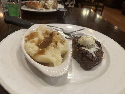 Perfectly cooked Filet Mignon with garlic butter and delicious mashed potatoes and gravy.