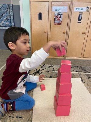 Building a pink tower out of blocks