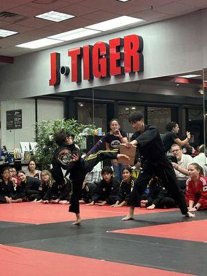 Breaking the final board to secure his black belt! And what an honor that his own Master Kang held the board!