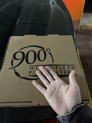 Size of pizza vs my hand. This is their "Large pizza" A JOKE.