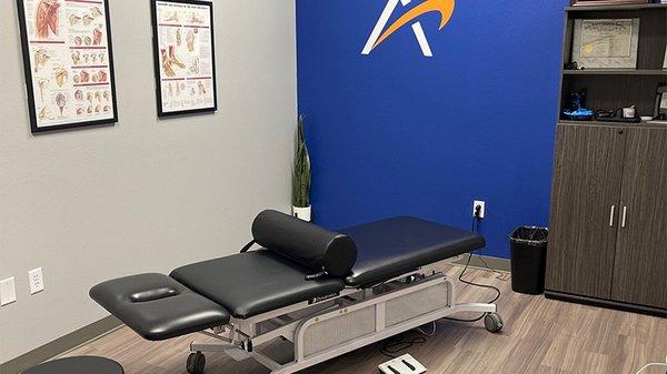 A look inside the treatment room at Airrosti Brownsville. A treatment table is shown in the center of the room.