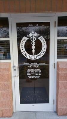 This is the door to the dental office with the logo and hours included.