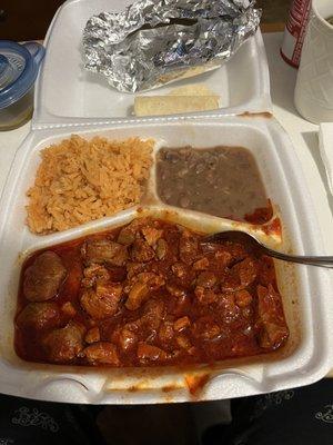 Puerco guisado (pork stew), rice, beans, green hot sauce and five tortillas.