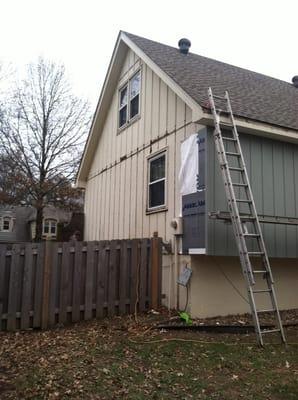 Work in progress shot showing wood rot on the left and new siding on the right.