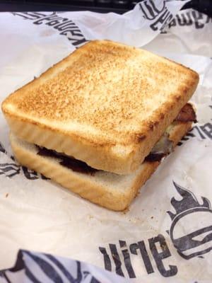 W 7th St Burger. Onion Rings, BBQ Sauce, and more on Texas Toast.