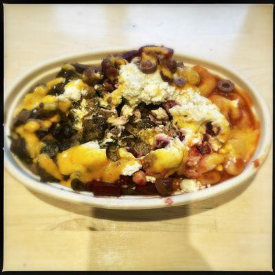 Custom bowl with steak, gîtante beans, beet salad, additional veggies, garlic spread, and hot sauce