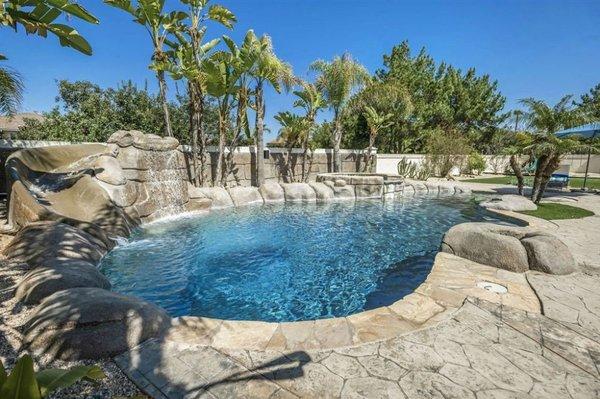 Beautiful tropical style pool with waterfall and slide with great rock scape.