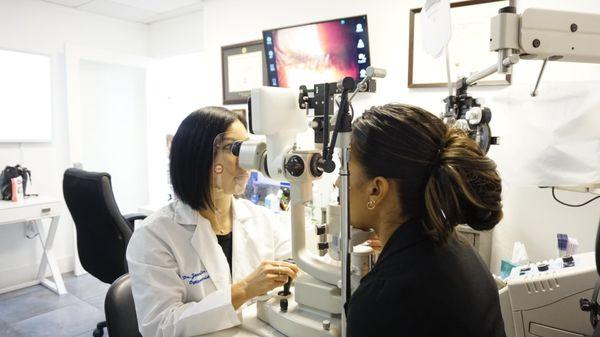 Dr Lee examining a patients eyelashes with are Digital Slit Lamp