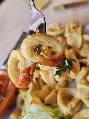 A fork holding a couple of Calamari from the appetizer.