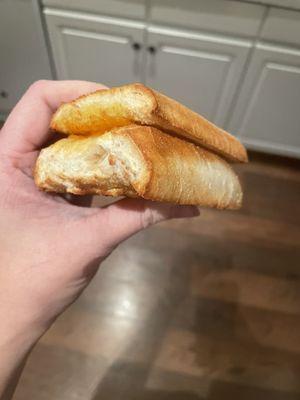 Side-view of the weird, tasteless lump of bread. There is a little bit of cheese, but you won't taste it.