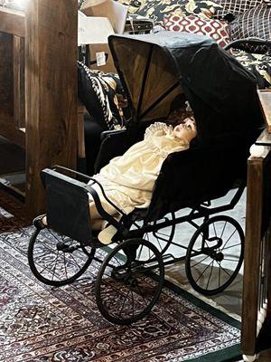 Creepy doll in vintage carriage