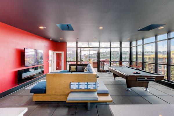 Rooftop clubhouse with pool table, couch, fireplace and T.V.