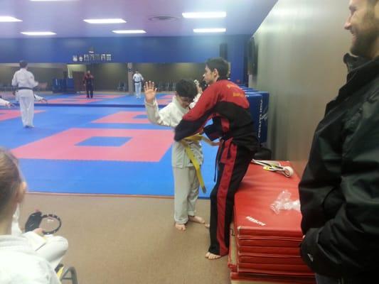 Sensei Dylan awarding my son with his yellow belt :-) We love Dylan! His enthusiasm is through the roof!