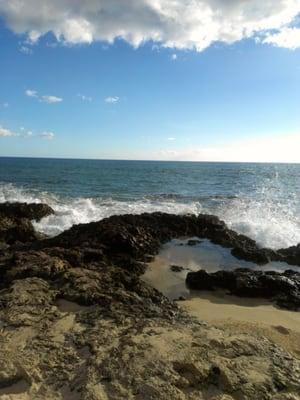 Waves crashing against rocks on shore.