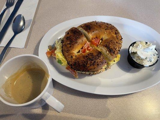 Espresso in a mug. Veggie egg sandwich with chive cream cheese on the side.