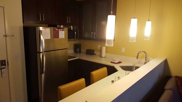 Full size kitchen featuring dishwasher, refrigerator, and seating.