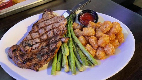 Strip steak with asparagus.  I substituted tator tots for the whipped potatoes that normally come with it.