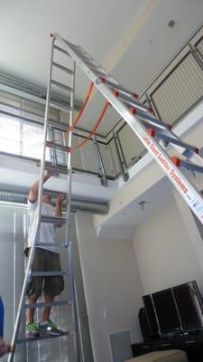 Setting up a huge ladder to install a ceiling fan in my loft.  20 ft off the ground.