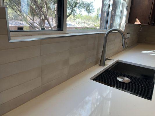 A new quartz countertop paired with a stylish porcelain backsplash!